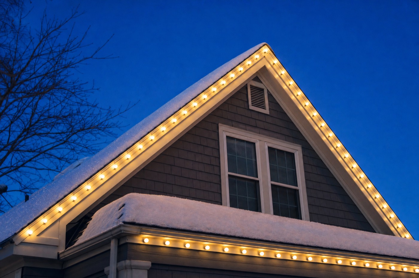 Snowy gable outlined in evenly spaced warm white C9 bulbs