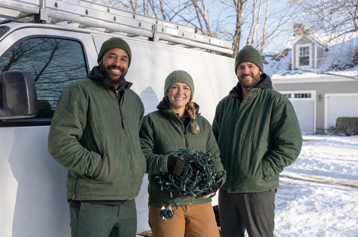 Three Northpine crew members smiling in front of a work van